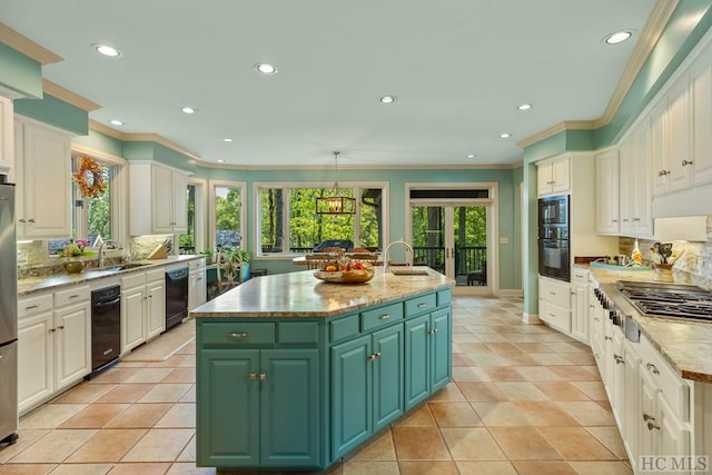 kitchen featuring green cabinetry, sink, a center island with sink, and black appliances