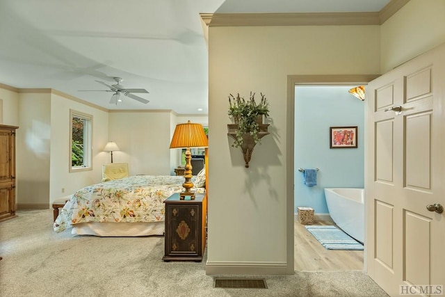 bedroom featuring light carpet, ornamental molding, and ceiling fan