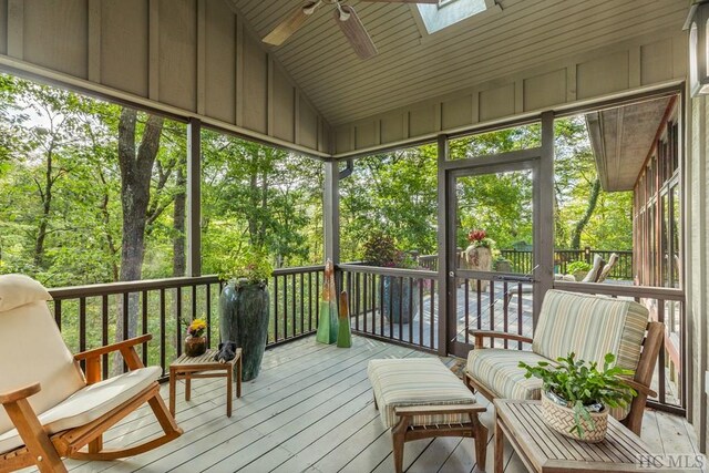 sunroom / solarium featuring vaulted ceiling with skylight and ceiling fan