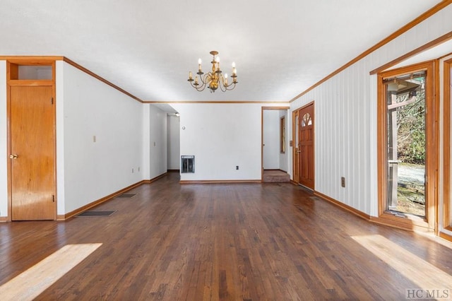 unfurnished living room featuring dark hardwood / wood-style flooring, ornamental molding, and an inviting chandelier