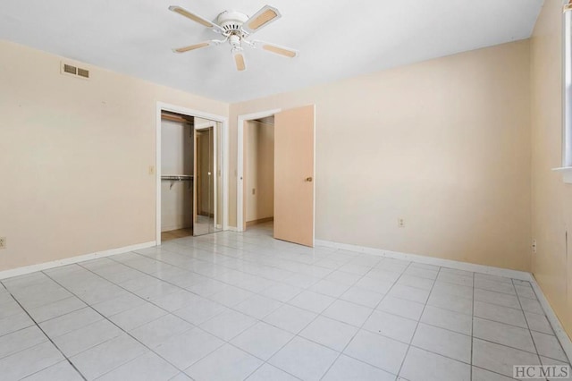 unfurnished bedroom featuring light tile patterned flooring, ceiling fan, and a closet