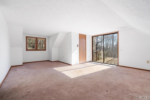 additional living space with lofted ceiling, light carpet, and a wealth of natural light