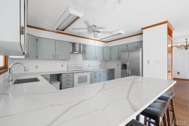 kitchen featuring wall chimney range hood, sink, stainless steel fridge, white range with electric stovetop, and kitchen peninsula