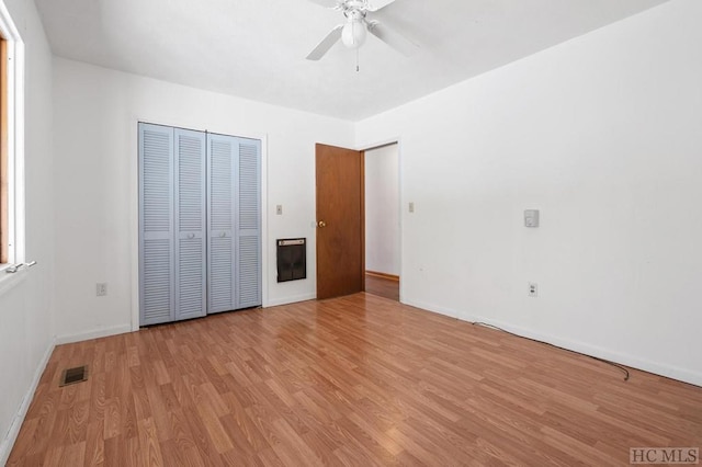 unfurnished bedroom with ceiling fan, light hardwood / wood-style floors, and a closet