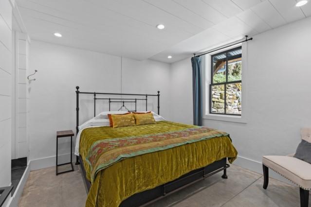 bedroom with concrete flooring, baseboards, and recessed lighting