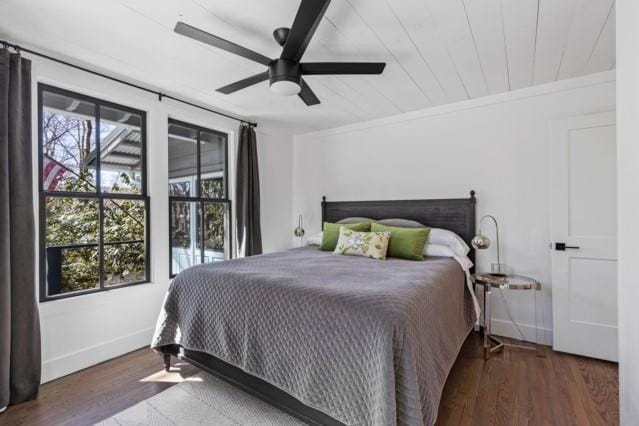bedroom featuring baseboards, a ceiling fan, crown molding, and wood finished floors