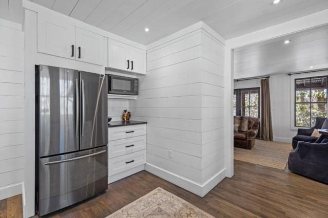 kitchen featuring white cabinets, freestanding refrigerator, black microwave, recessed lighting, and dark wood-type flooring