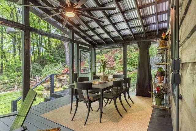 sunroom with a healthy amount of sunlight, outdoor dining space, and ceiling fan
