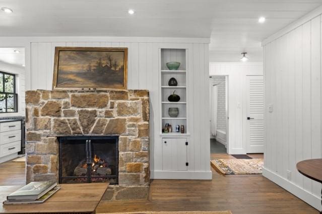 room details with built in shelves, wood finished floors, and a fireplace