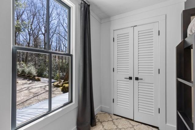 doorway featuring baseboards and a healthy amount of sunlight