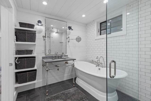 full bath with a freestanding tub, tile walls, recessed lighting, vanity, and a stall shower