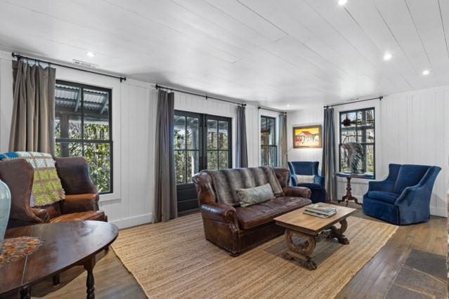 living room featuring wood finished floors, recessed lighting, and a decorative wall