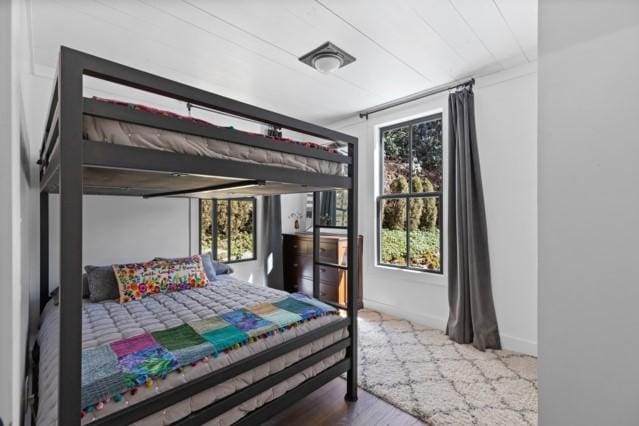 bedroom with baseboards and multiple windows
