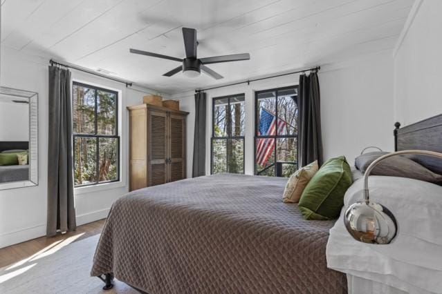 bedroom with ceiling fan, baseboards, and wood finished floors