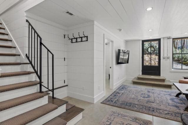 foyer entrance with concrete floors, visible vents, recessed lighting, stairway, and baseboards