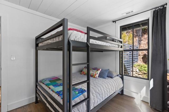 bedroom with visible vents, baseboards, and wood finished floors