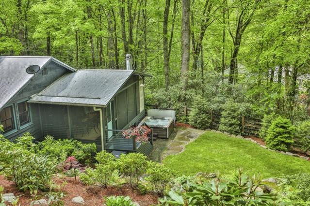 view of outdoor structure with a view of trees and a sunroom