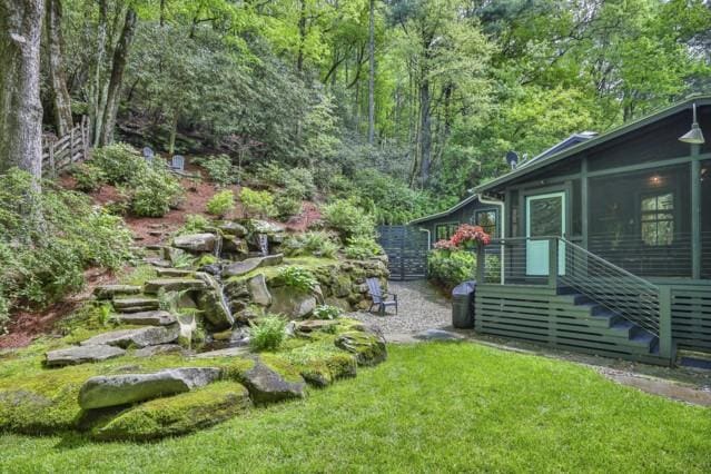 view of yard featuring a forest view and a sunroom