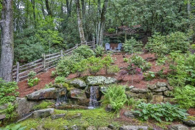 view of yard with a forest view and fence