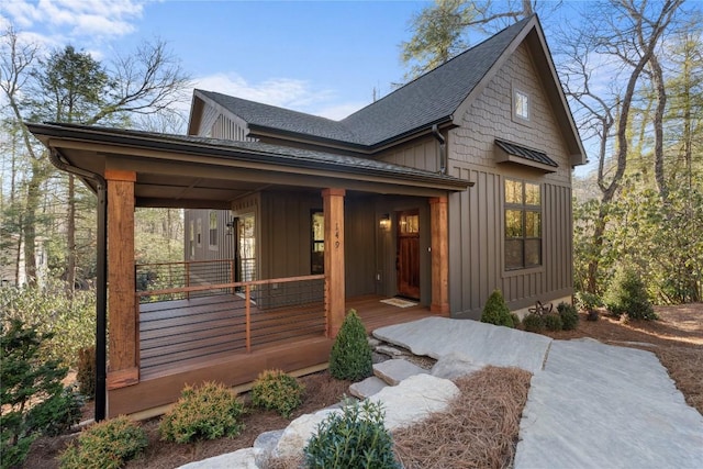 149 Woodland Hill Dr, Highlands, NC 28741 - view of front facade with covered porch, a shingled roof, and board and batten siding
