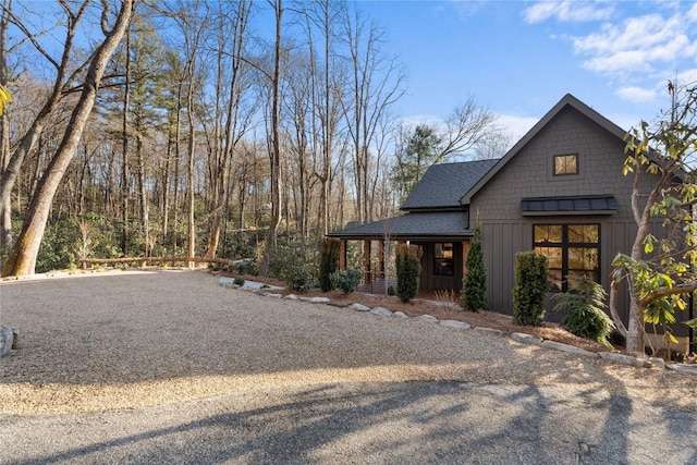 149 Woodland Hill Dr, Highlands, NC 28741 - view of side of property with covered porch, board and batten siding, and a shingled roof