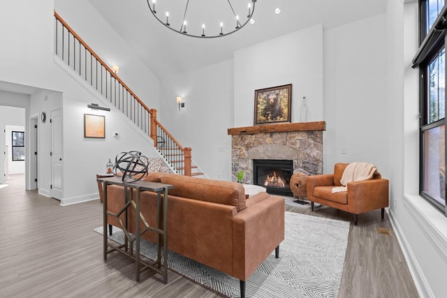 149 Woodland Hill Dr, Highlands, NC 28741 - living room featuring stairway, a towering ceiling, light wood-style flooring, and a stone fireplace