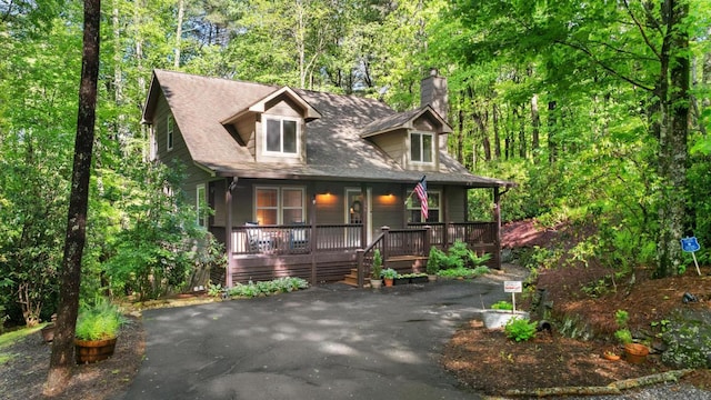 599 Tower Rd, Sapphire, NC 28774 - view of front of home featuring a chimney, covered porch, and a view of trees