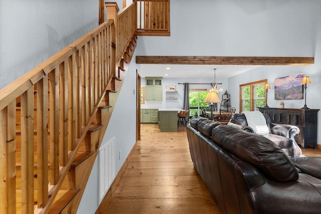 599 Tower Rd, Sapphire, NC 28774 - living area featuring light wood-style floors, stairs, a high ceiling, and a chandelier