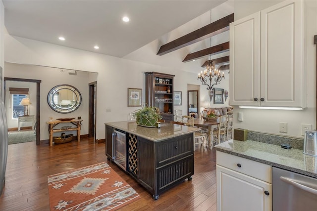 kitchen featuring white cabinetry, light stone counters, a notable chandelier, and dark wood-style floors