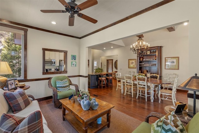 living area featuring wood finished floors, baseboards, recessed lighting, crown molding, and ceiling fan with notable chandelier