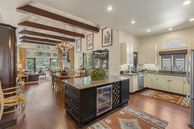 kitchen with wine cooler, a chandelier, dark wood finished floors, appliances with stainless steel finishes, and a sink