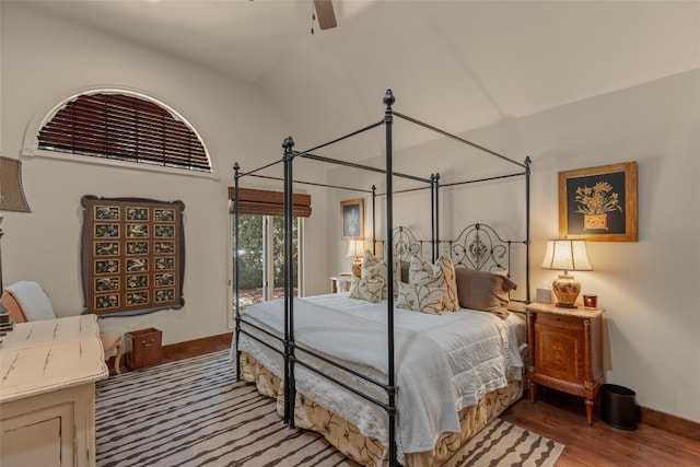 bedroom featuring access to exterior, baseboards, and wood finished floors