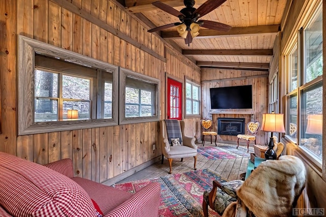 sunroom with ceiling fan, lofted ceiling with beams, and wood ceiling