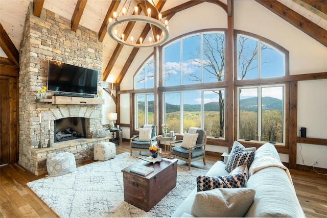 living room featuring high vaulted ceiling, hardwood / wood-style flooring, beam ceiling, and a notable chandelier