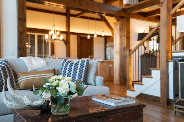 living area featuring stairs, wood finished floors, and a notable chandelier