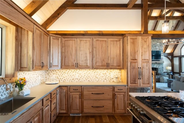kitchen featuring dark wood-style flooring, tasteful backsplash, high end range, a sink, and lofted ceiling with beams