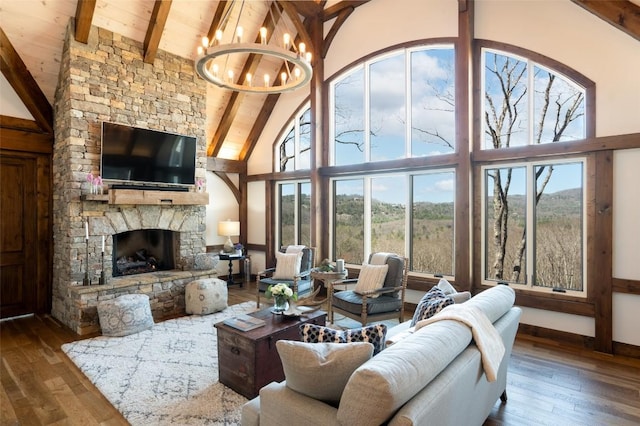 living area featuring wood ceiling, high vaulted ceiling, beamed ceiling, wood-type flooring, and a chandelier