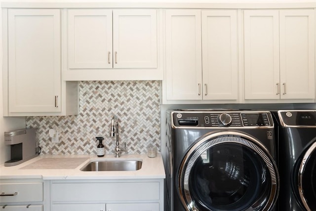 clothes washing area with independent washer and dryer, a sink, and cabinet space