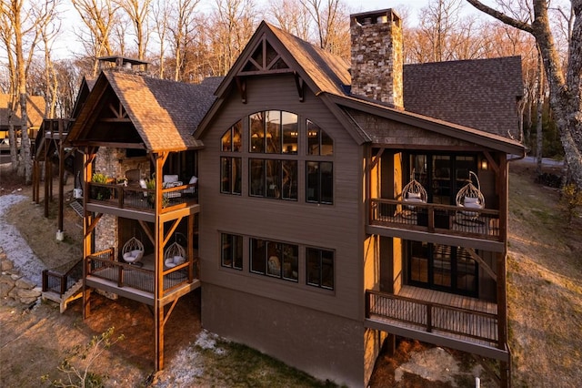back of property with a balcony and a chimney