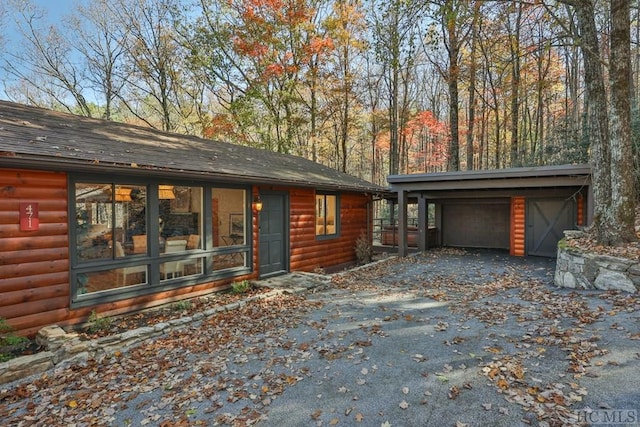 view of front of home featuring a garage, an outbuilding, and a carport