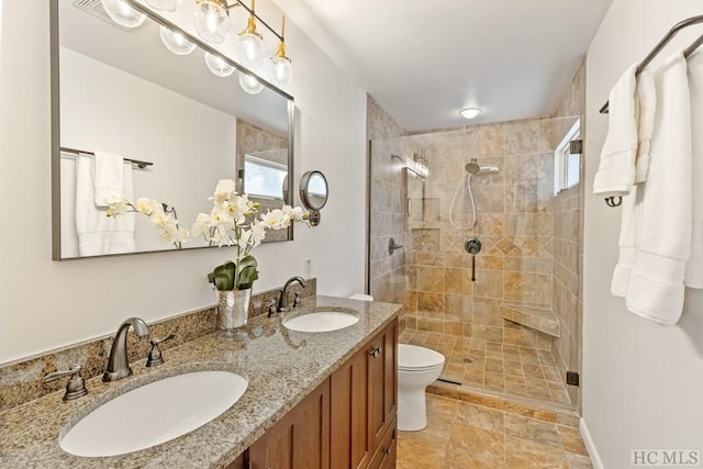 bathroom with toilet, a shower with door, and vanity