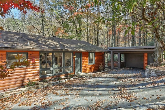 view of front facade with a carport, an outdoor structure, and a garage