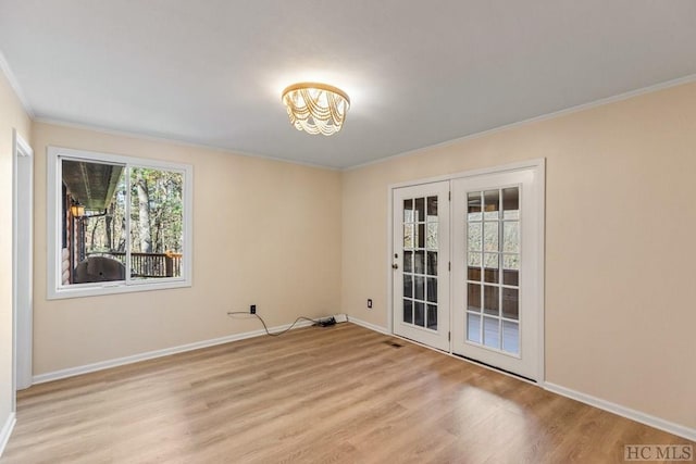 empty room with light wood-type flooring, crown molding, and french doors