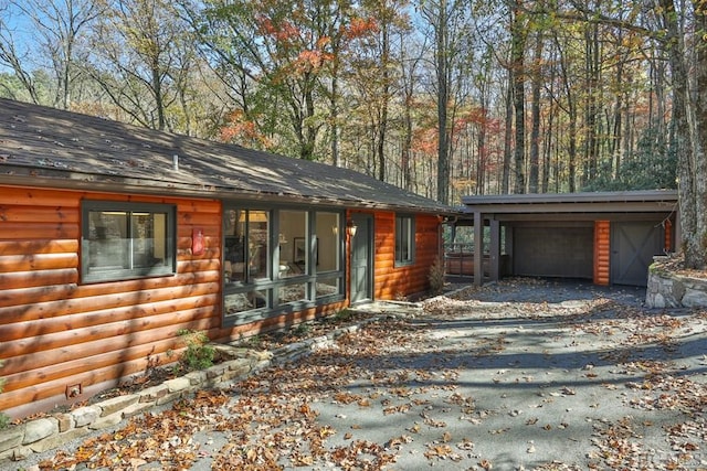 view of front of home with a garage, an outdoor structure, and a carport