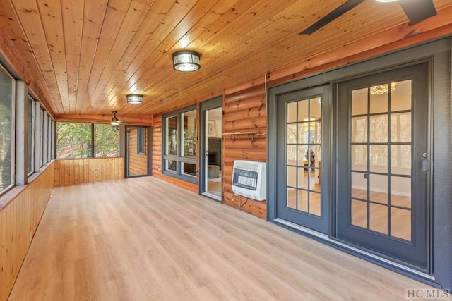 unfurnished sunroom with ceiling fan, heating unit, and wooden ceiling