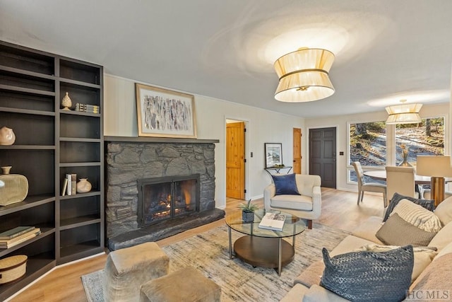 living room with a stone fireplace and hardwood / wood-style flooring