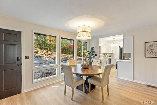 dining room featuring sink and light hardwood / wood-style floors