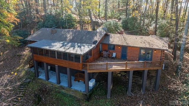 rear view of house with a sunroom and a deck