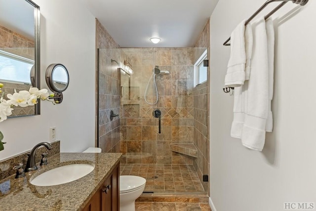 bathroom with vanity, toilet, and a shower with door