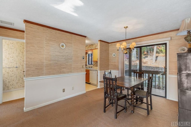 carpeted dining space with ornamental molding and an inviting chandelier